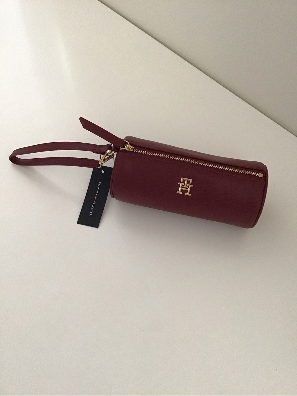 Tommy Hilfiger burgundy cylindrical handbag.